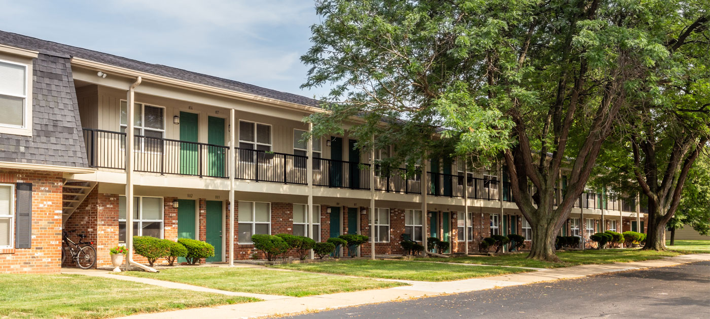 Sypialnia z leśnym pejzażem Sypialnia na poddaszu z łóżkiem i oknem wychodzącym bezpośrednio na las