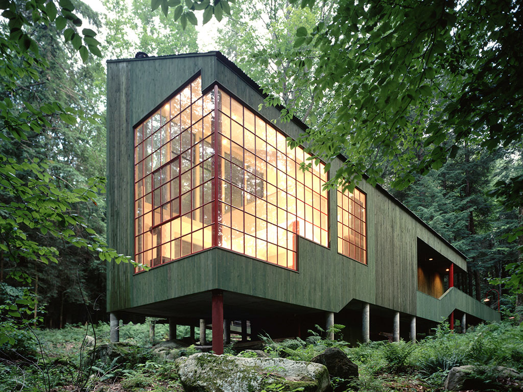 Taras z widokiem na leśną ostoję Taras drewniany z meblami ogrodowymi wychodzący na gęsty las z leśną ścieżką obok