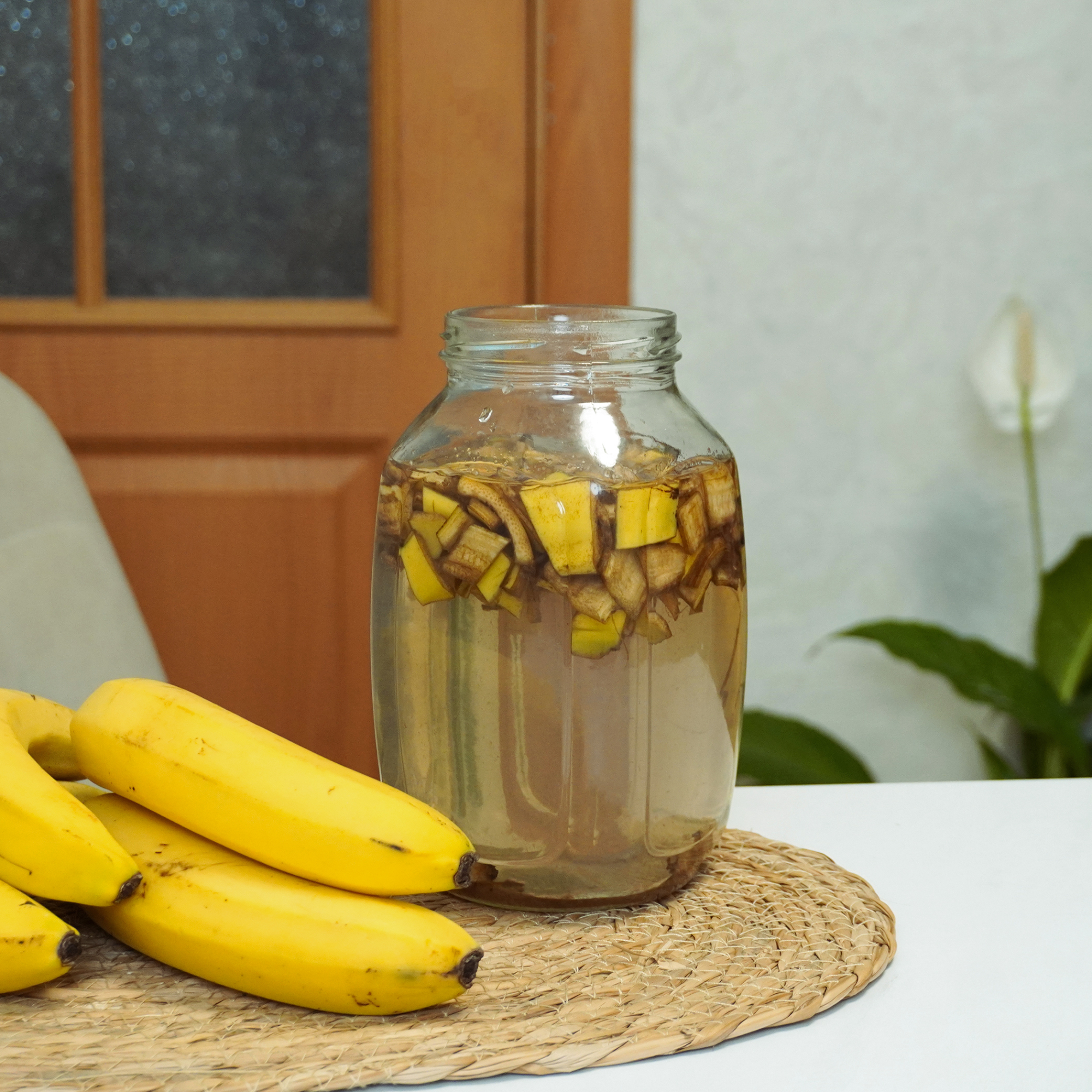 rozdrabnianie skórek do nawozu dłoń trzymająca garść rozdrobnionej skórki banana przed kompostownikiem
